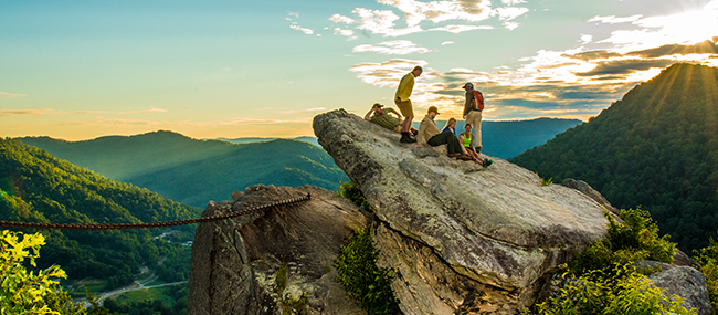Group of people sitting on rock among mountains at Pine Mountain State Resort Park